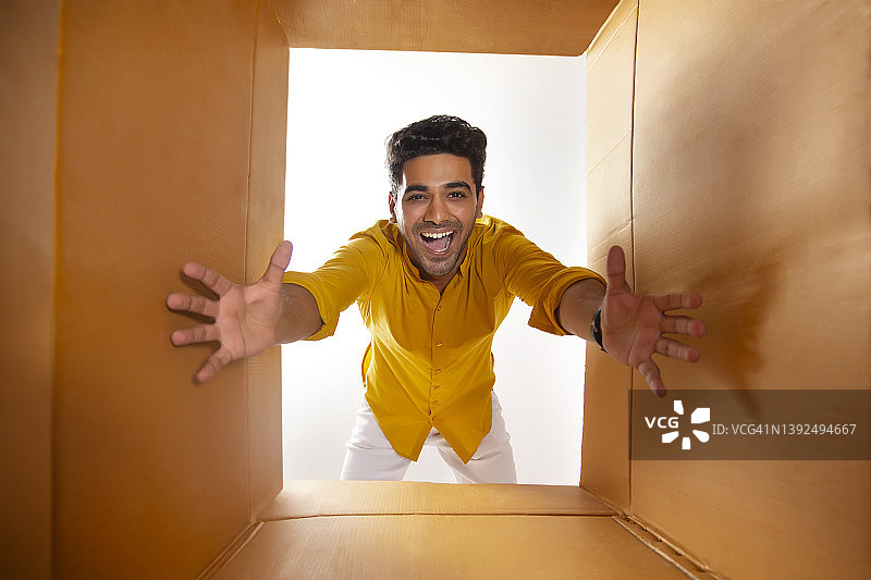 男人在纸箱后对着镜头摆姿势图片素材