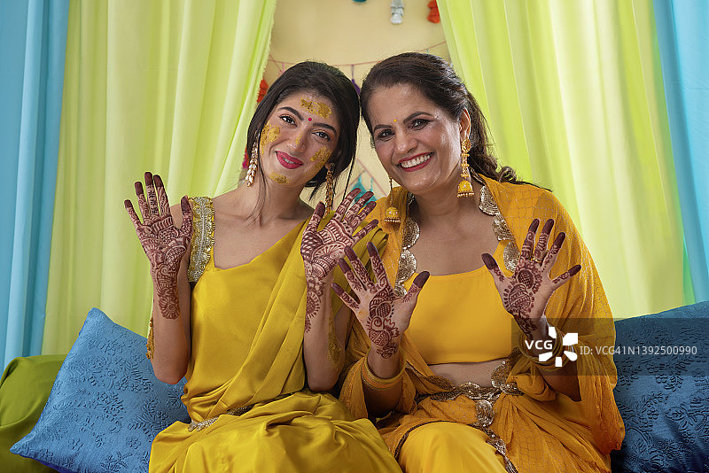 在Haldi仪式上，母女展示手掌上的曼海蒂彩绘图片素材