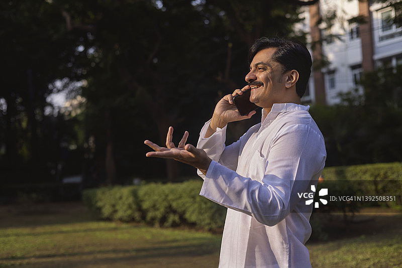 男人清晨在公园打电话图片素材