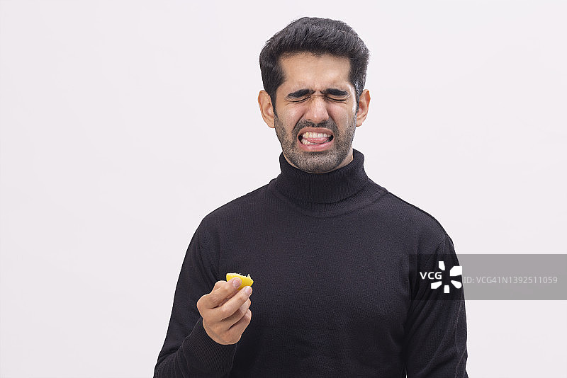 年轻人吸吮酸柠檬后的表情图片素材