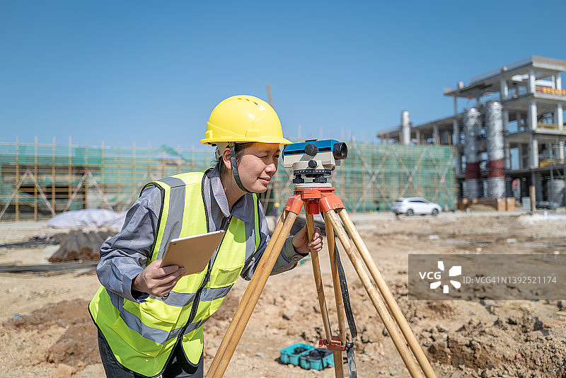 女土木工程师在建筑工地使用水平仪测量数据图片素材