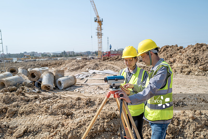 两位男工程师和女工程师一起使用仪器测量和观察数据图片素材