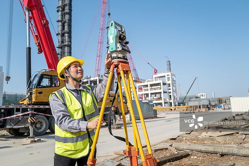 女工程师在建筑工地用经纬仪测量数据图片素材