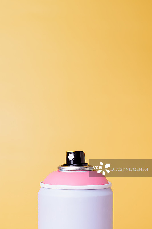 黄色背景上的气雾剂喷罐图片素材