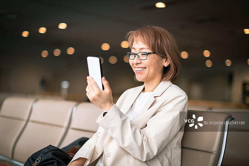 在机场大厅长椅上工作的女商人图片素材