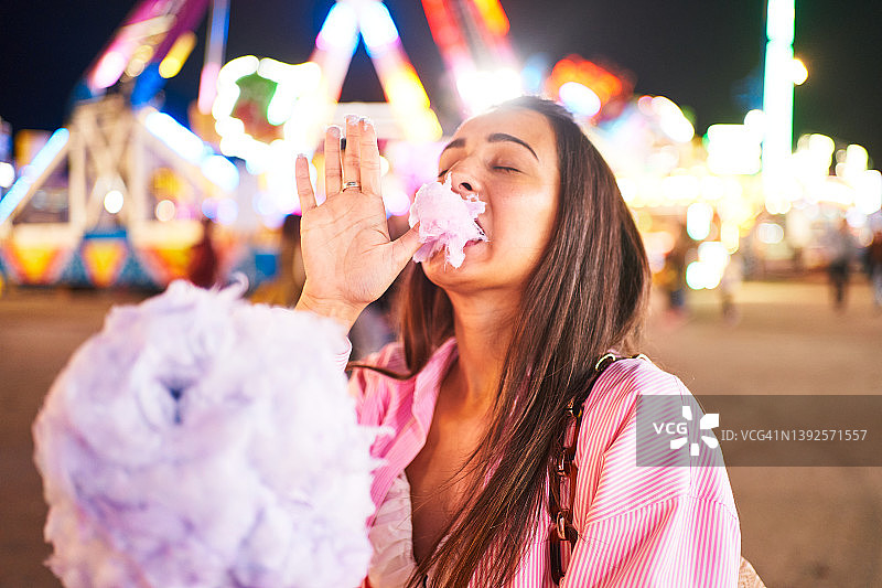在景点附近吃棉花糖的女人图片素材