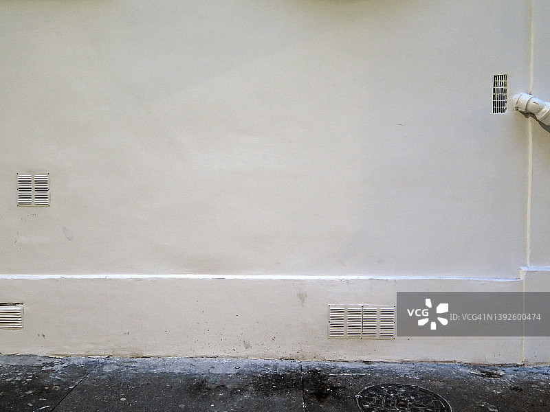 巴黎空旷的风化白色墙壁，带通风口和人行道图片素材