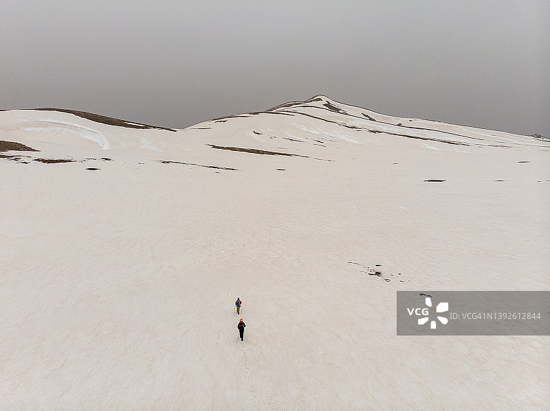 冬季雪山之巅登山队航拍图片素材