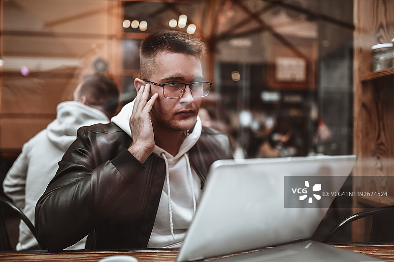 现代男工程师在咖啡厅用笔记本电脑进行视频会议图片素材