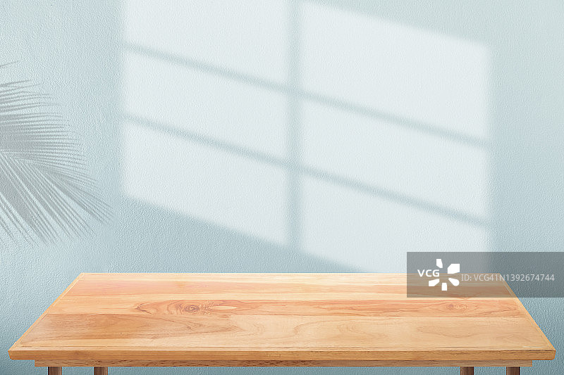 蓝色混凝土墙上的阴影与木桌图片素材