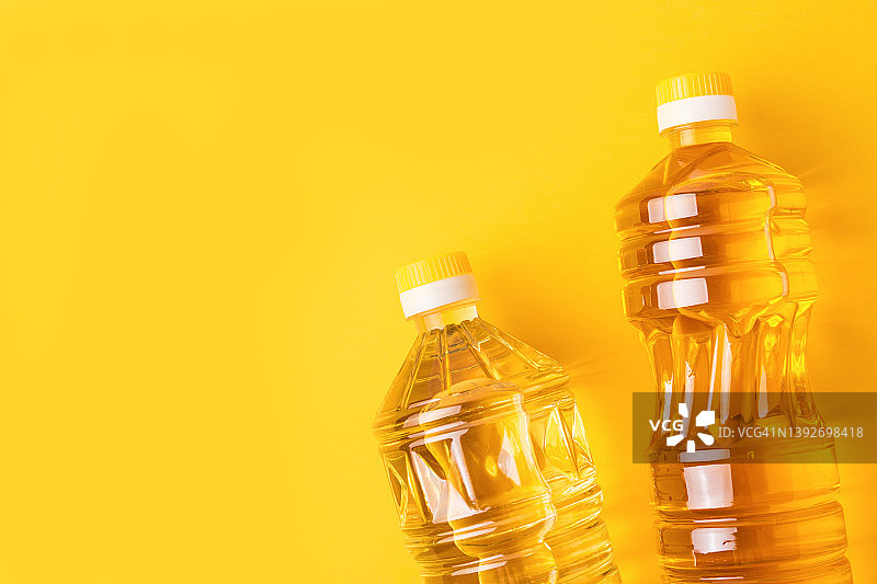 黄色背景下的塑料瓶装向日葵油图片素材