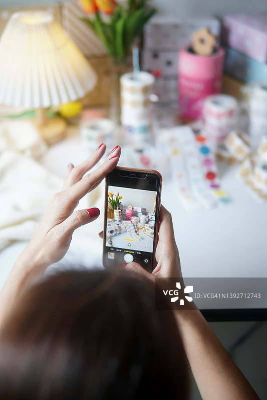 小型企业主使用智能手机拍摄产品照片，用于在线营销图片素材