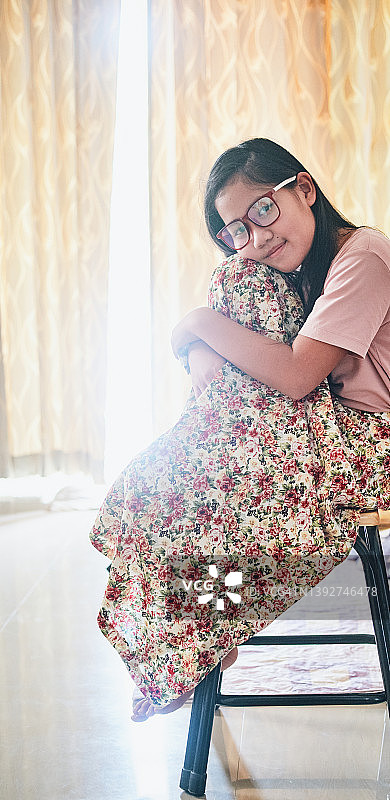 穿着漂亮图案裙子的女孩坐在椅子上图片素材