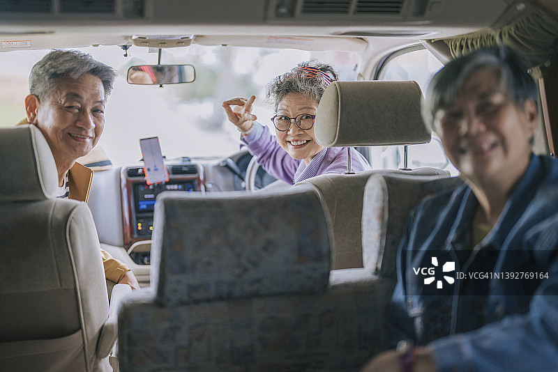 乘坐房车旅行的亚洲华人老年朋友对着镜头微笑图片素材