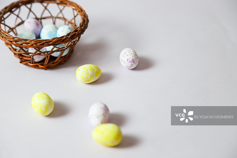 2022年复活节快乐。紫色背景上的黄色花朵、水仙花、鸡蛋和小鸡。篮子里的小鸡。极简概念复活节贺卡，带有文字副本位置。图片素材