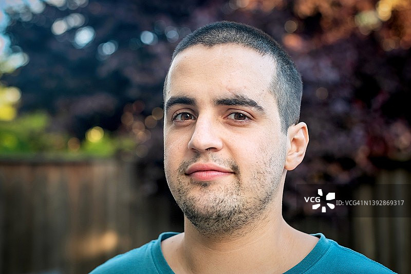微笑的西班牙裔青年男子看着镜头图片素材