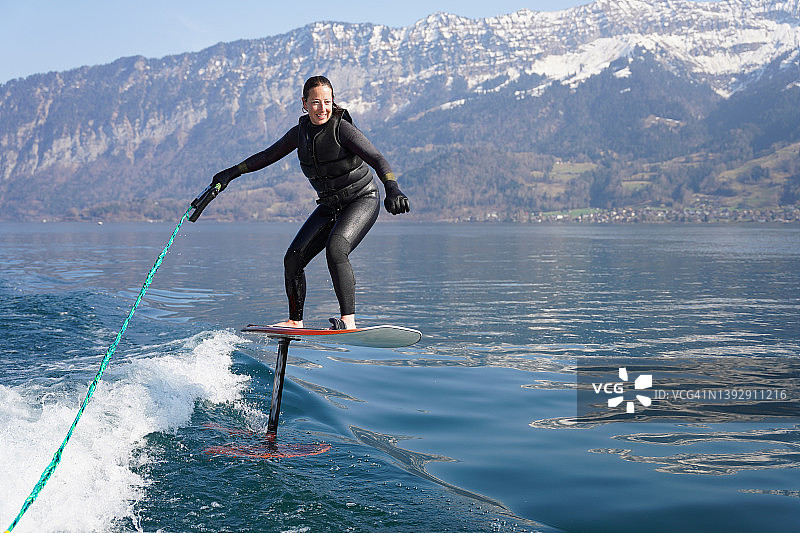女人在船后玩尾波滑水板图片素材
