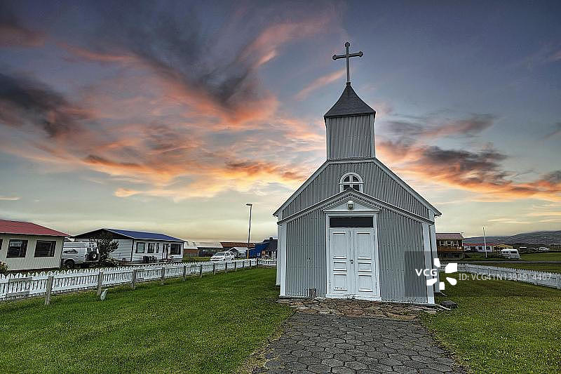 村庄里的灰色木制教堂和住宅，傍晚的天空，位于冰岛东区博尔加峡湾的巴卡格尔济图片素材