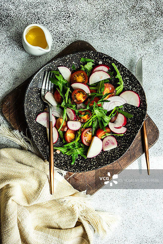 火箭菜、樱桃番茄、红洋葱和橄榄油沙拉碗俯视图图片素材