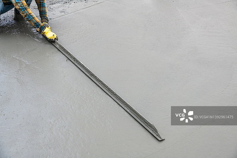 工人们帮助铲水泥、浇筑混凝土路面并完成收尾工作——库存图片图片素材
