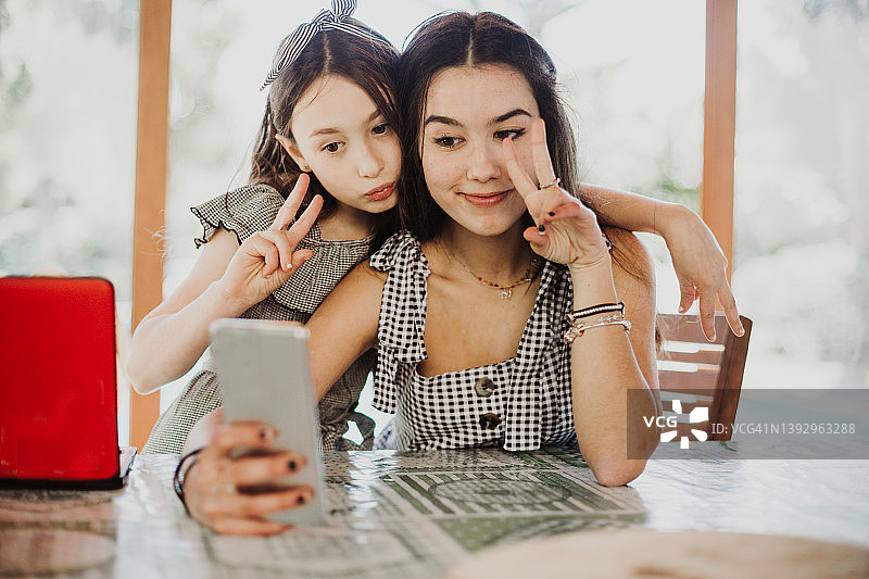 兄妹用智能手机自拍并做鬼脸图片素材