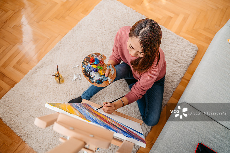 年轻女艺术家在家绘画图片素材