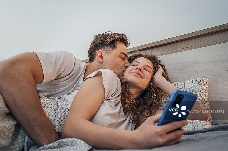 相爱的年轻情侣躺在床上图片素材