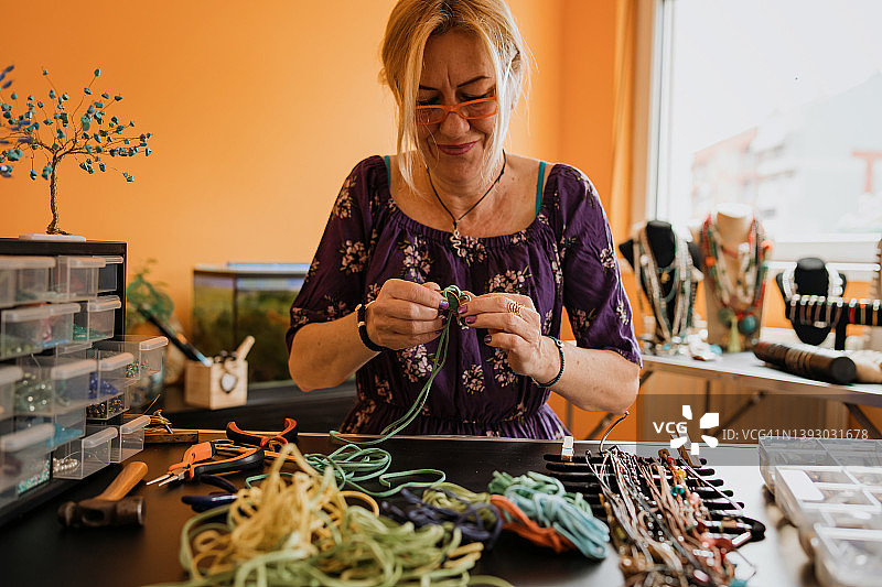 老年妇女制作手工珠宝，小生意图片素材