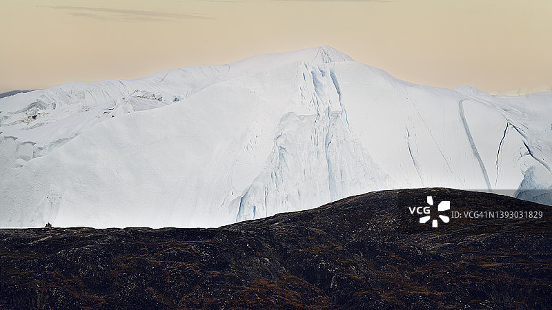 北极地区冰山后的黄色天空日落图片素材