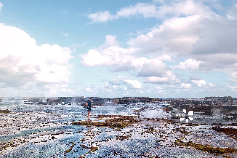 男子在汤加塔普的岩石池塘边行走图片素材