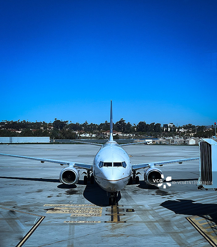 停靠在航站楼廊桥的商用喷气式飞机图片素材