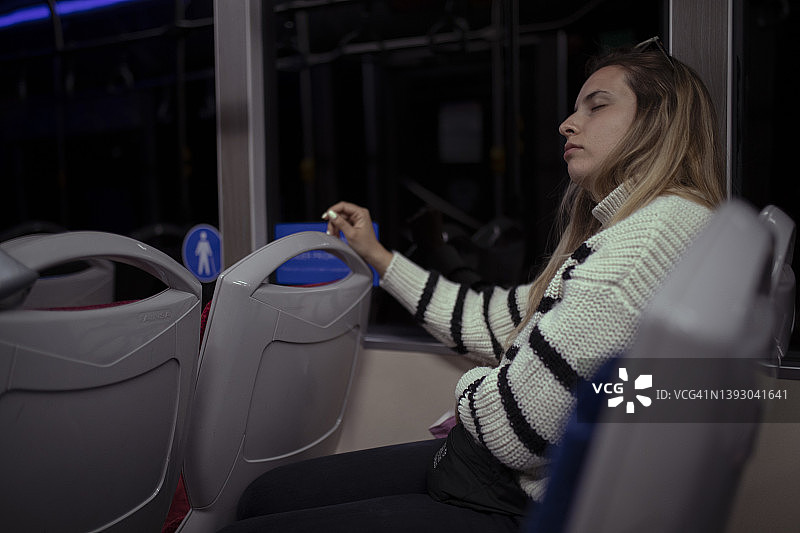 女人在夜间乘坐地铁时小睡图片素材