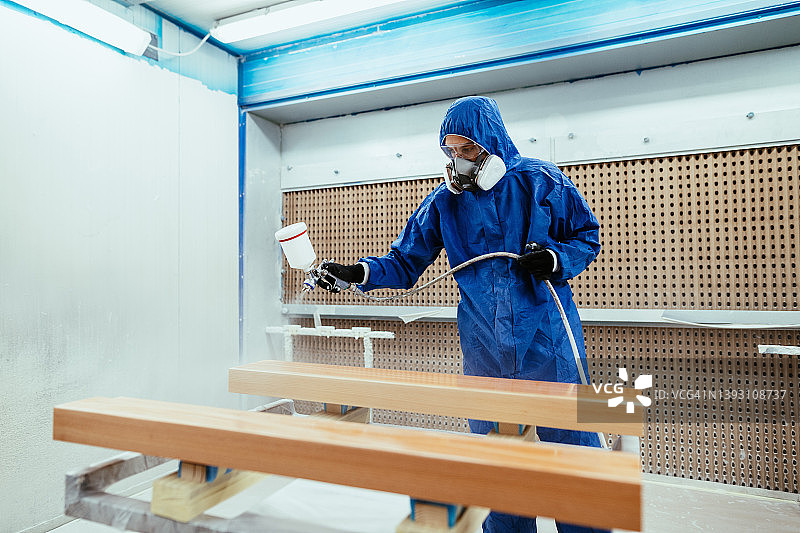 油漆匠在喷漆室中为半导体零件喷漆图片素材