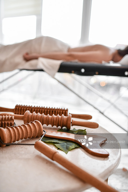 女患者躺在按摩床旁边的工具旁，等待按摩开始图片素材