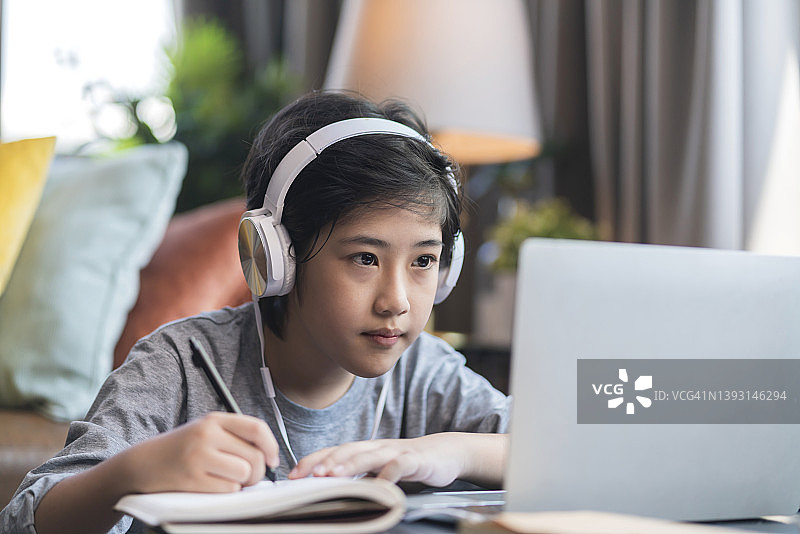 亚洲儿童在家使用笔记本电脑在线学习图片素材