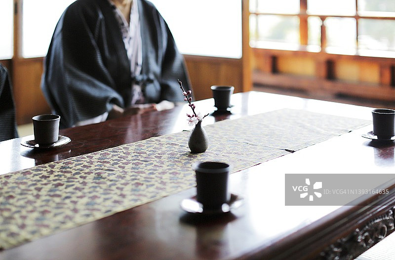 身穿日式浴衣的男人坐在榻榻米房间里图片素材