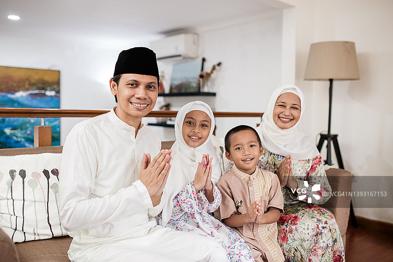 亚洲家庭在家庆祝开斋节，请求宽恕图片素材