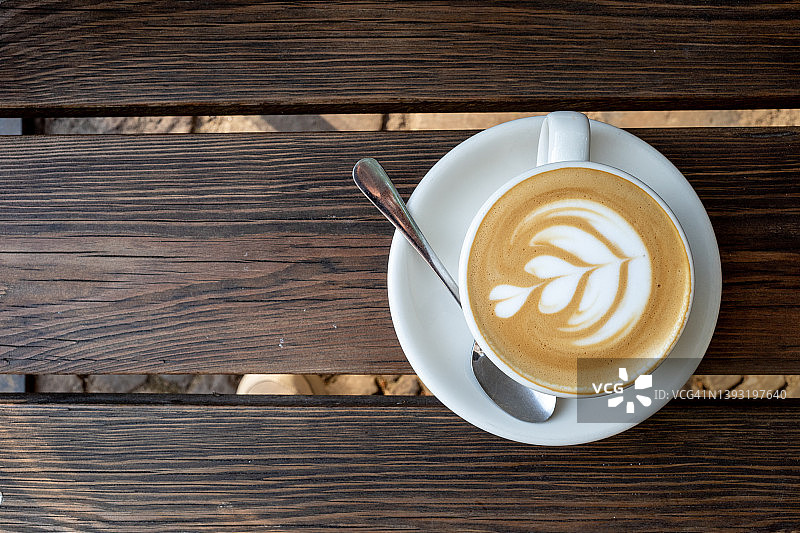 木制长椅上的心形拉花卡布奇诺图片素材