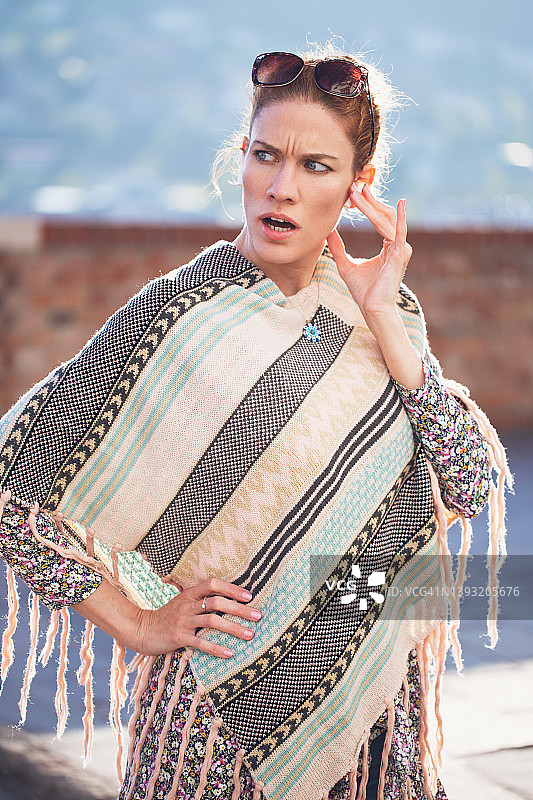 惊讶地打电话的年轻红发女子图片素材