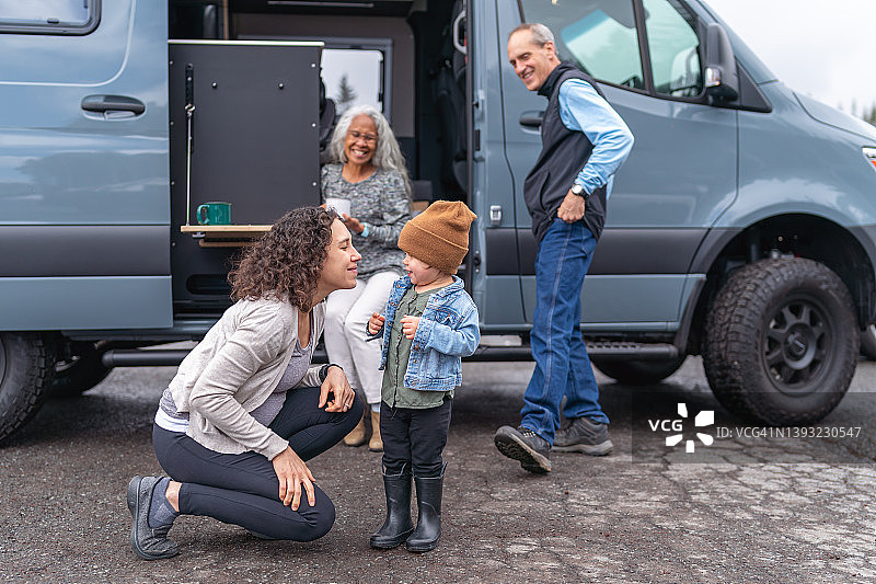 蹒跚学步的女孩和怀孕的妈妈与家人一起露营图片素材