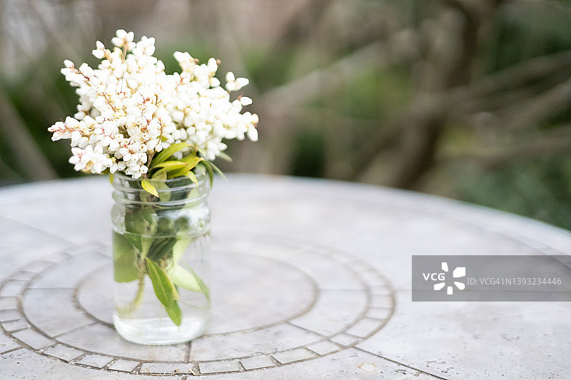 户外玻璃罐中的小束铃兰花图片素材