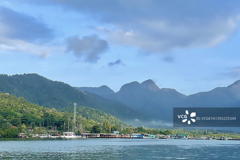 象岛：萨拉克佩特湾美丽景色，海滨有色彩缤纷的渔村和山景，阳光明媚，蓝天白云图片素材