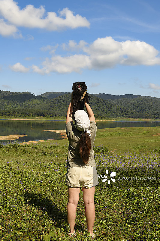 年轻女子与爱犬互动的背影图片素材