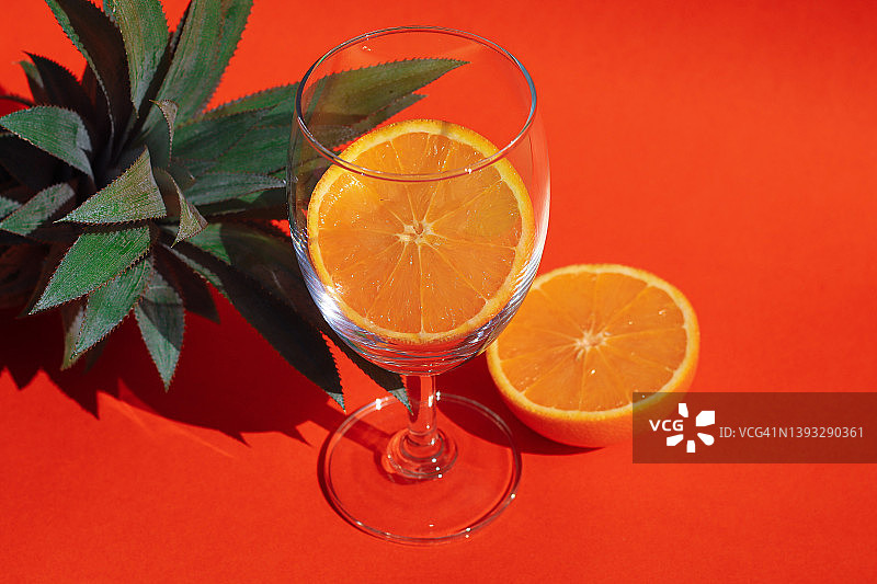 玻璃杯中的橙子切片，背景是菠萝图片素材