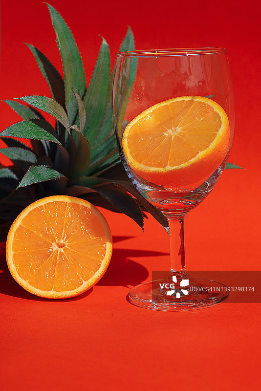 玻璃杯中的橙子，菠萝为背景图片素材