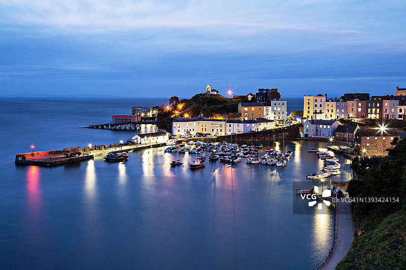 英国坦比港的蓝色时刻：夜灯与水面倒影图片素材