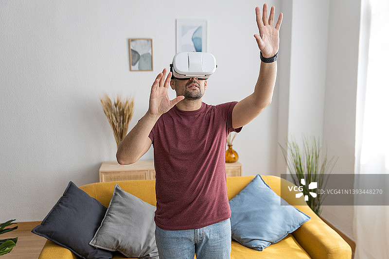 年轻男人在家中佩戴VR眼镜图片素材