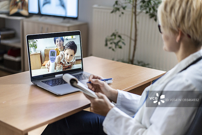 新冠疫情期间向医生展示体温测量结果的小男孩图片素材