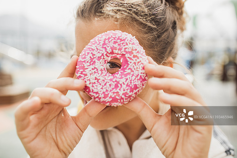 女人手持甜甜圈遮脸趣味概念图片素材