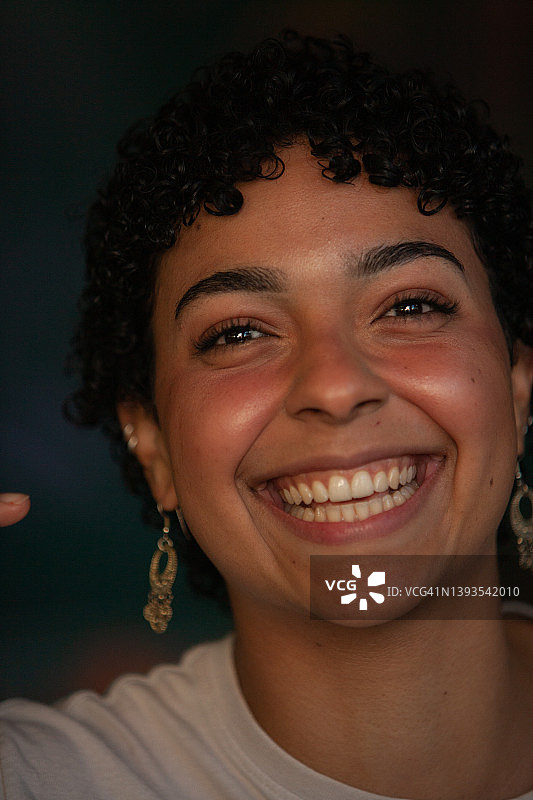 竖版对着镜头微笑的美丽年轻女人肖像图片素材